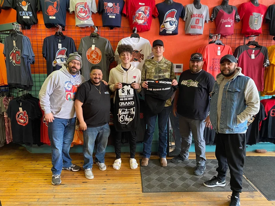 A group in the store holding custom printed shirts